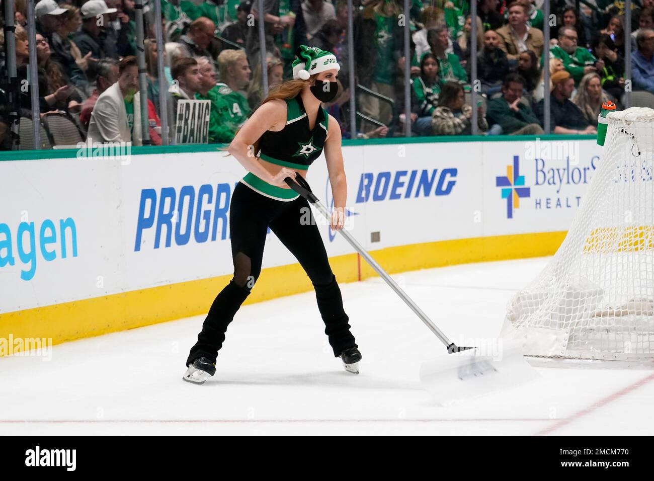 A member of the Dallas Stars Ice Girls clears frost off the rink