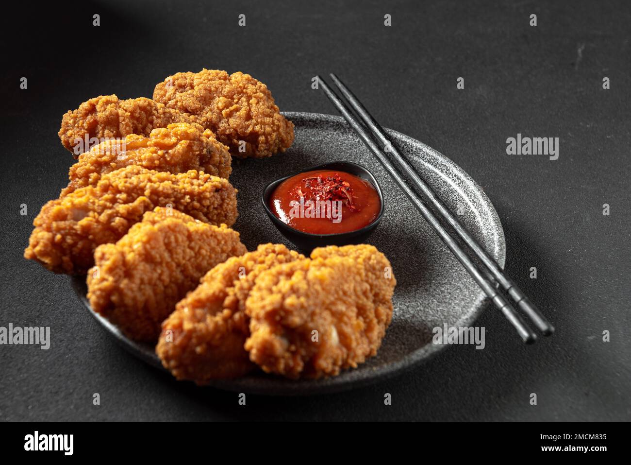 Asian meat deep-fried, breaded in oil in a plate on a dark stone background with copy space. Top view, flat plan Stock Photo