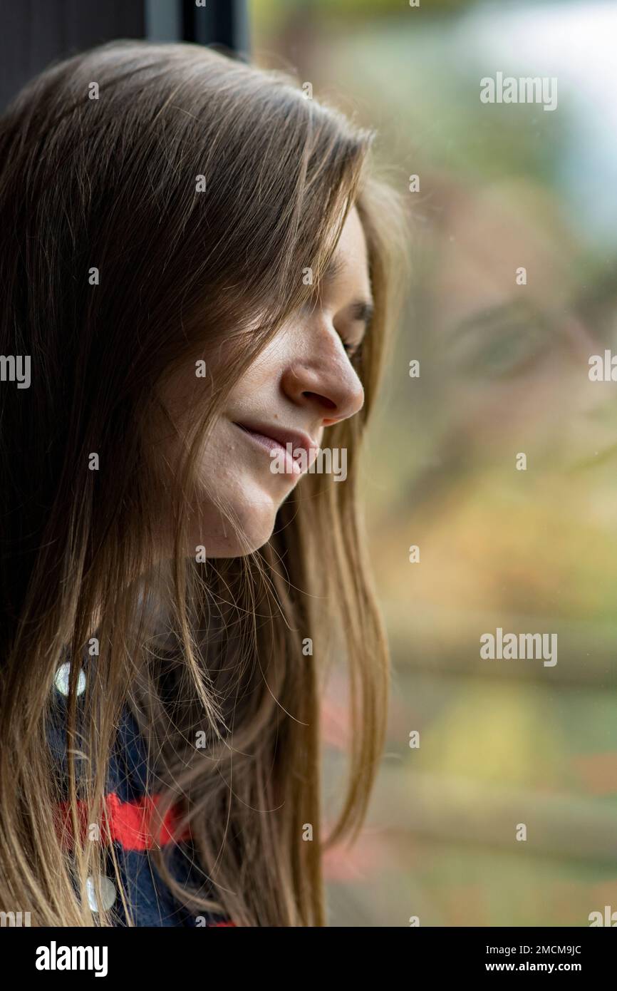 Sad woman looking out of the window Stock Photo - Alamy