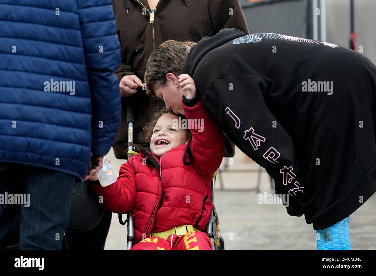 Linda Jackson, a tornado victim, kisses her friend's son, Jaquan Jackson, 3, in an evacuation