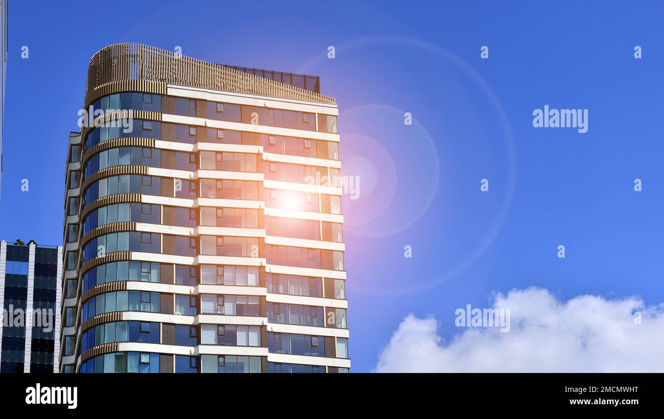 Exterior of a high modern multi-story apartment building - facade, windows and balconies. Stock Photo