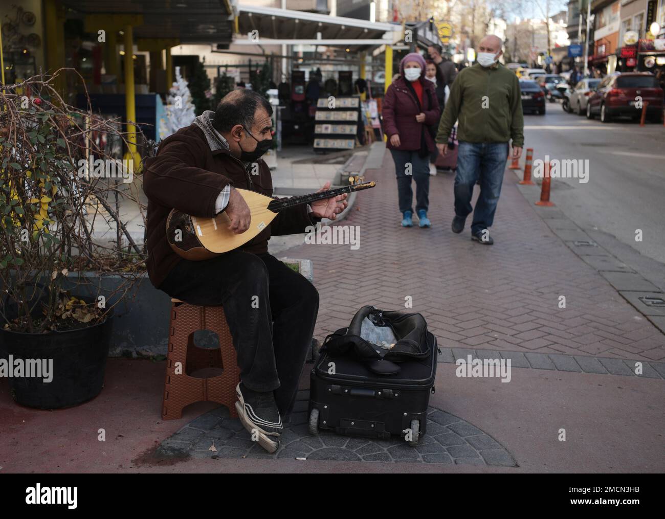 A man plays a saz or baglama, a traditional instrument of Turkish folk  music, to make some money in street, in Ankara, Turkey, Sunday, Dec. 12,  2021. Rampant inflation and unemployement are