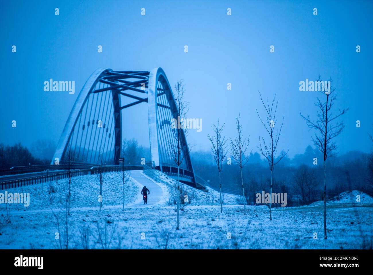 Hessisch Oldendorf, Germany. 22nd Jan, 2023. A cyclist rides along a winter snow-covered bike path. Credit: Lino Mirgeler/dpa/Alamy Live News Stock Photo