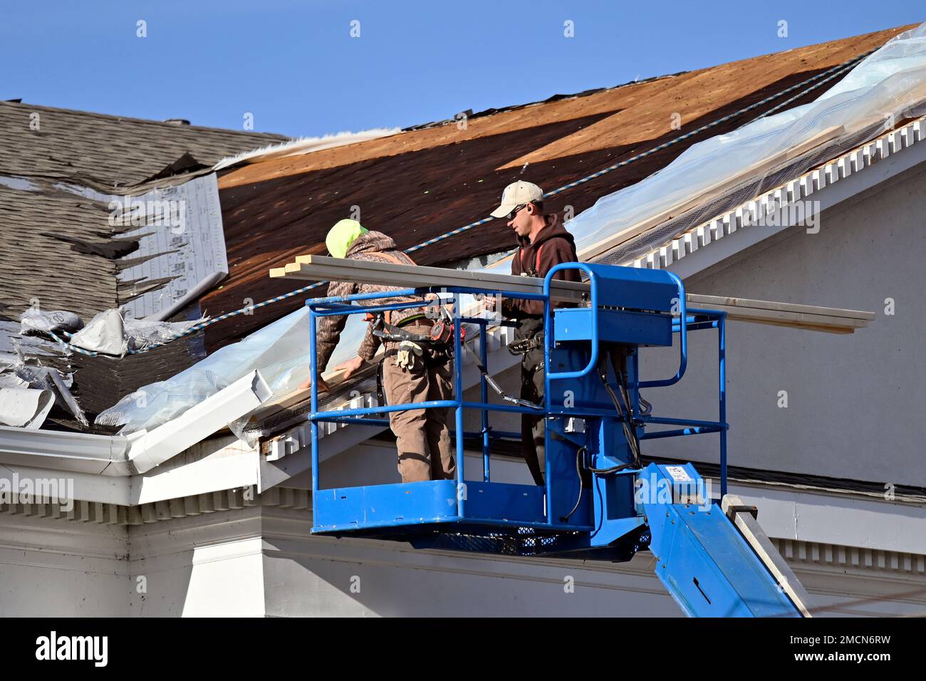 Workers try to seal the openings in the roof of the First Kentucky Bank