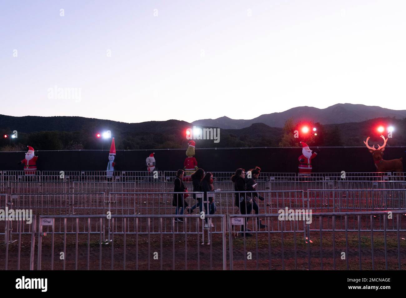 People walk past Christmas characters as they arrive at Holiday Road