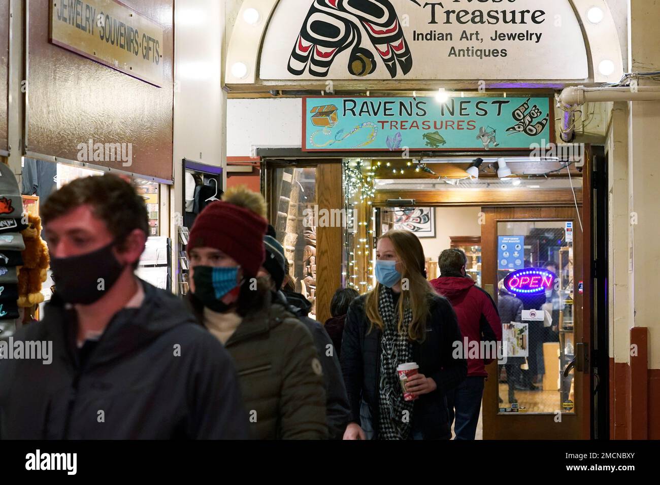 Customers leave the Raven's Nest Treasure shop in Pike Place Market,  Friday, Dec. 10, 2021, in Seattle. Two artists are facing federal charges  that they faked Native American heritage to sell works