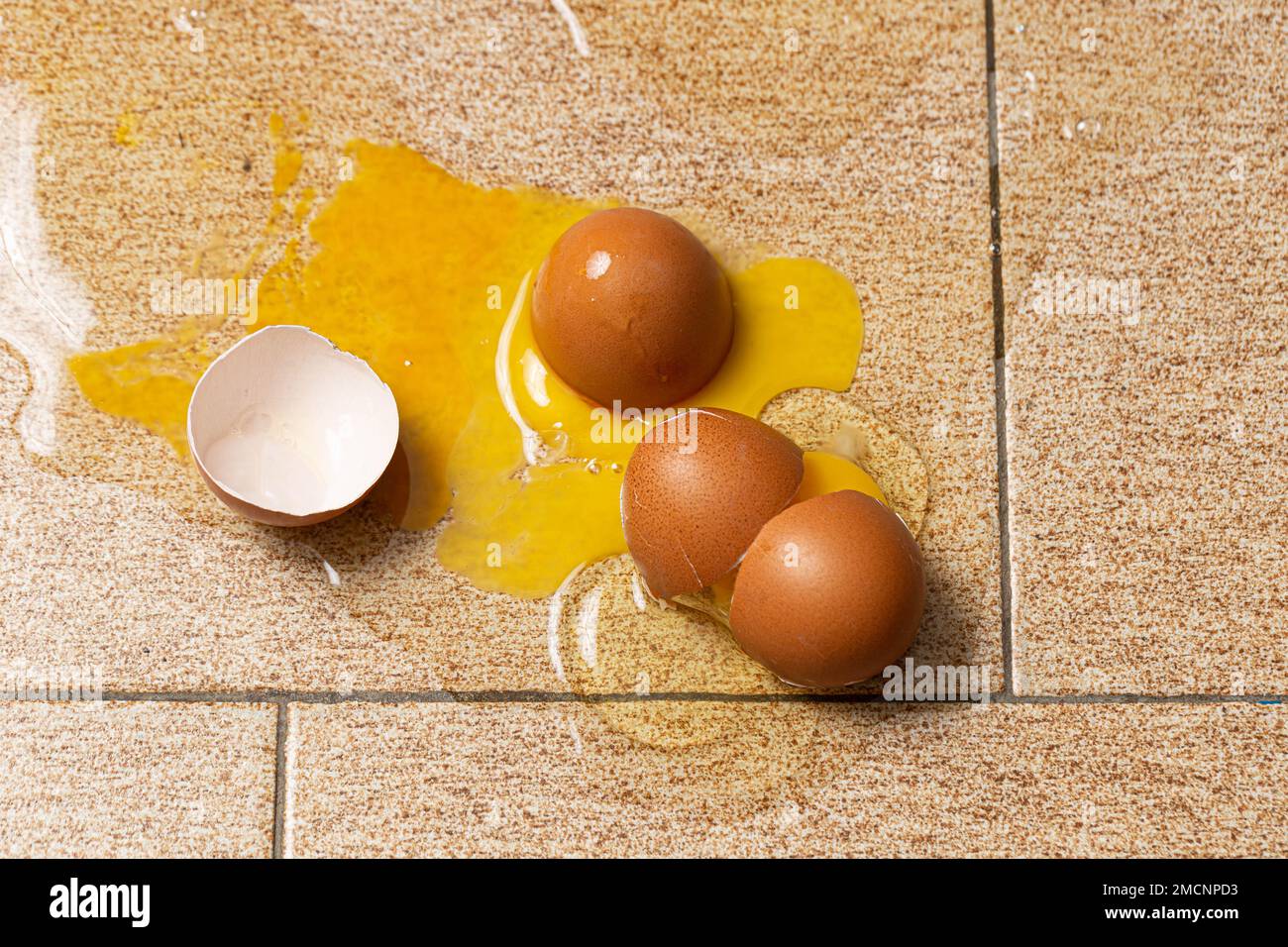 Cracked Eggs Macro Image: Yolk Spilled on the Floor Stock Photo