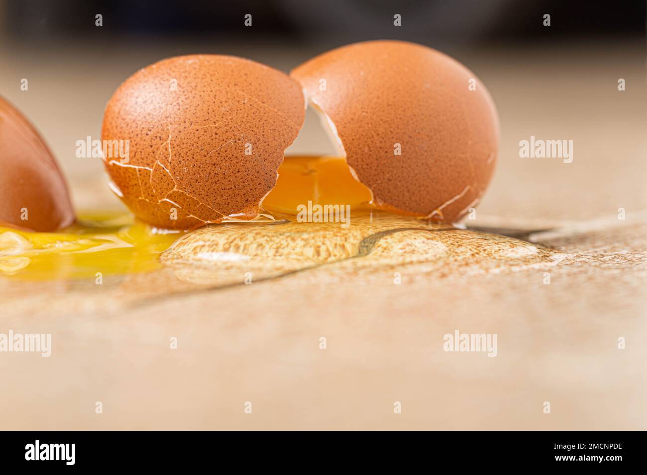 Cracked Eggs Macro Image: Yolk Spilled on the Floor Stock Photo