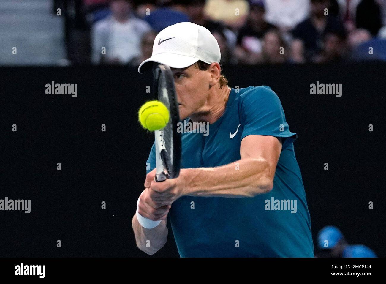 Jannik Sinner of Italy plays a backhand return to Stefanos Tsitsipas of Greece during their fourth round match at the Australian Open tennis championship in Melbourne, Australia, Sunday, Jan
