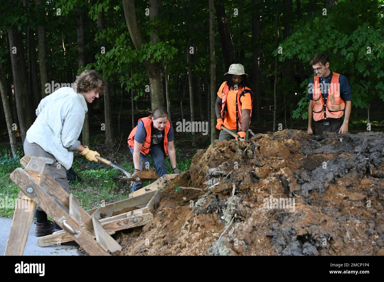 a-team-of-archaeologists-sift-through-a-large-mound-of-dirt-and-mud-for