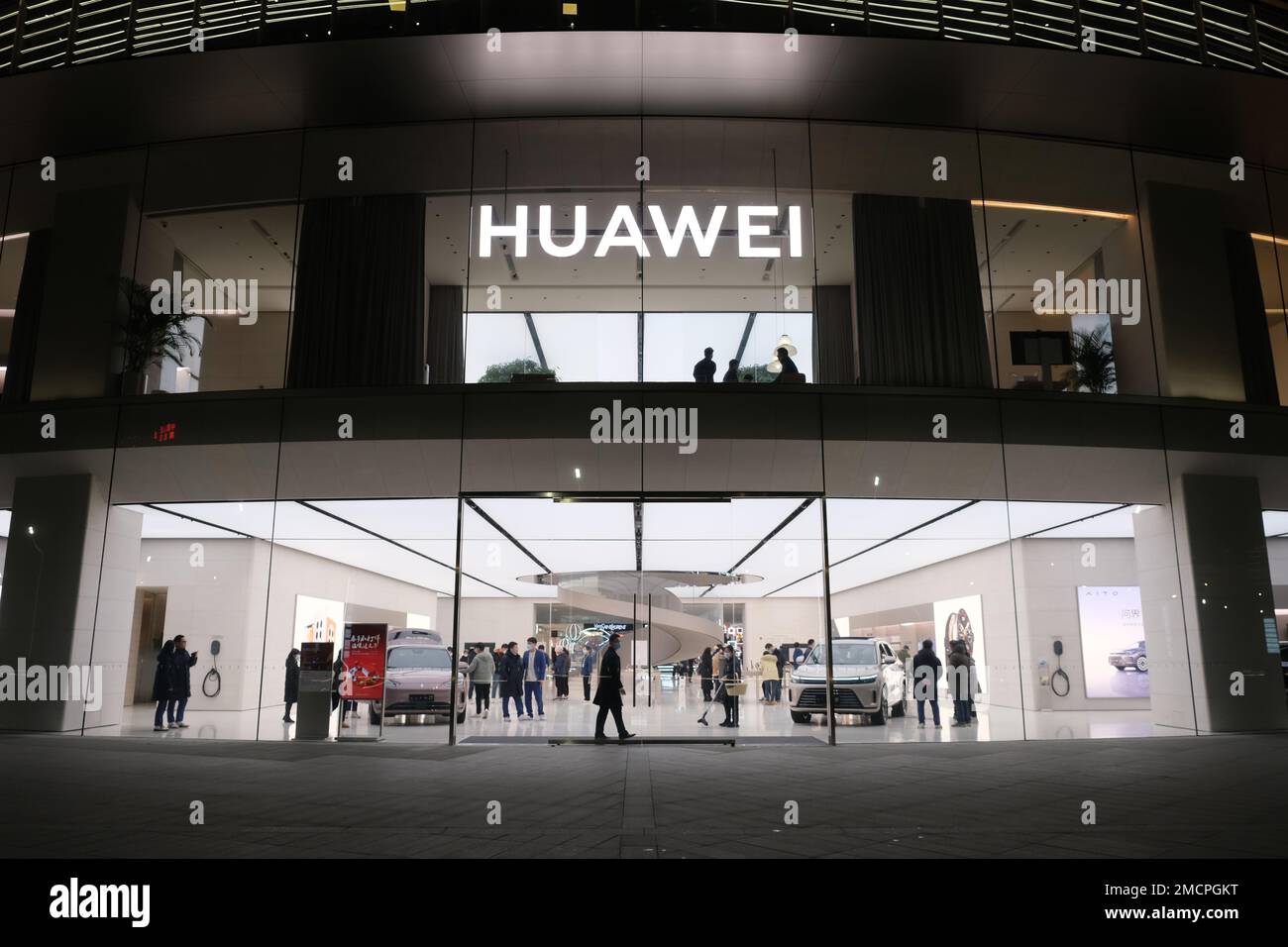 Wuhan,China-Jan.19th 2023: large HUAWEI flagship store with AITO electric cars and many people. Chinese customers buy electric car in HUAWEI store. Stock Photo