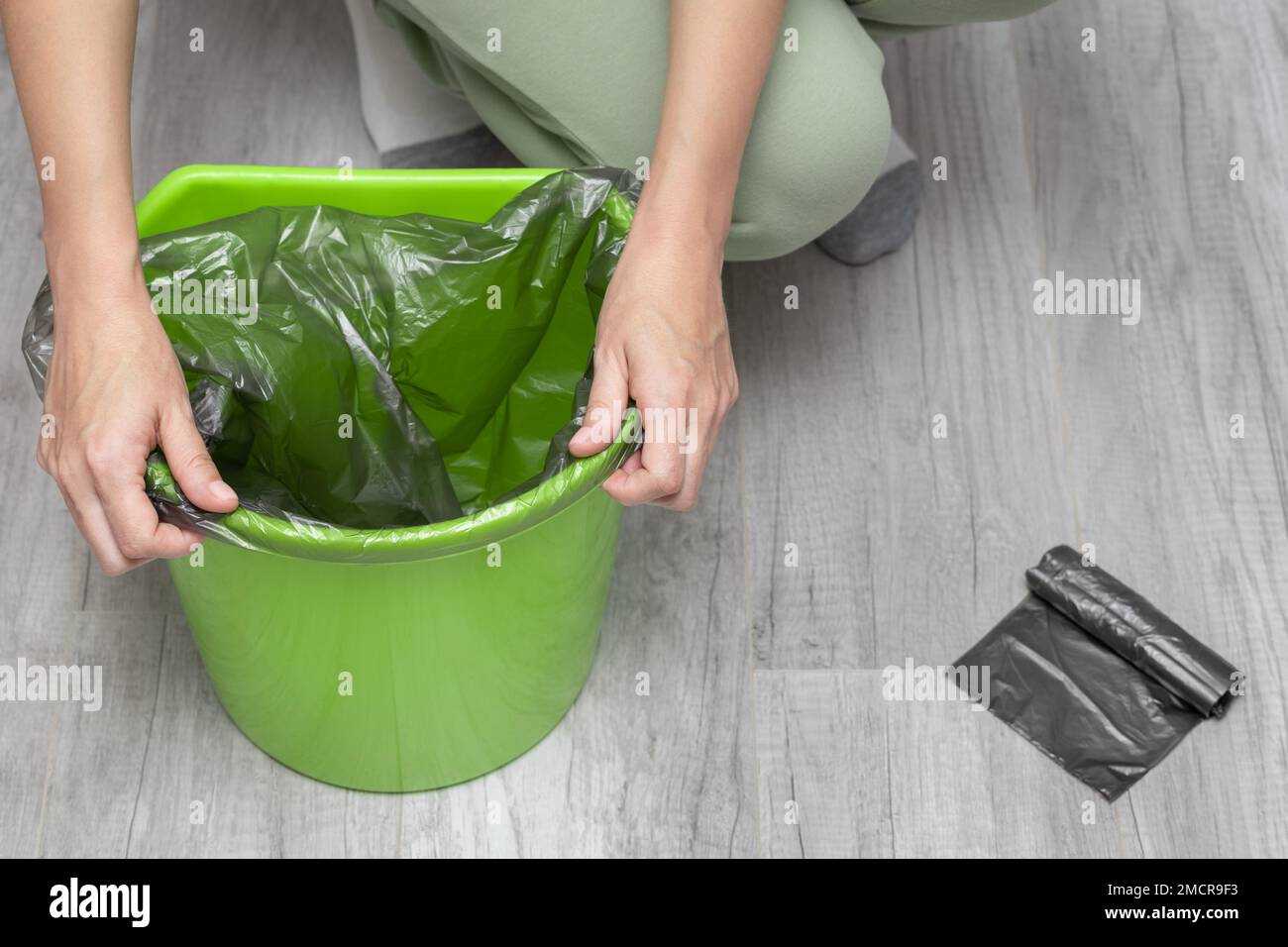 a man changes a garbage bag in a bucket. woman changing trash bag. empty trash bag. empty trash