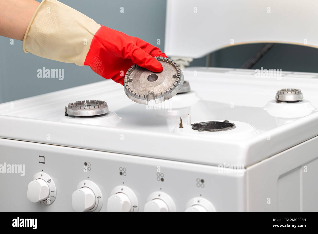 man washing the gas stove in the kitchen. man repairing a gas stove