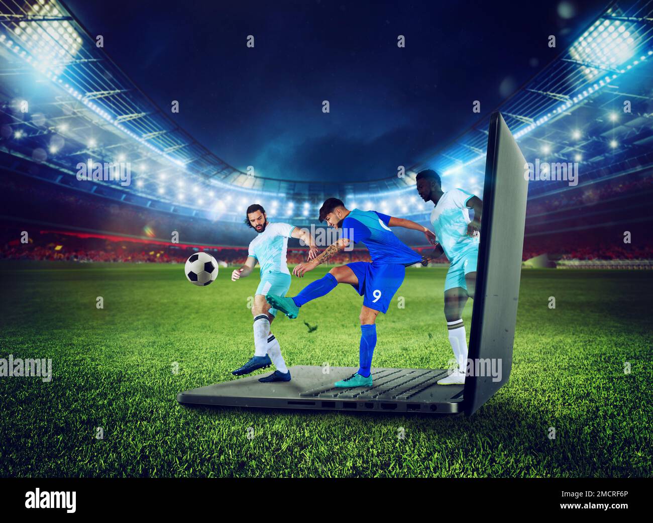 Soccer players play on a laptop, concept of tv streaming Stock Photo