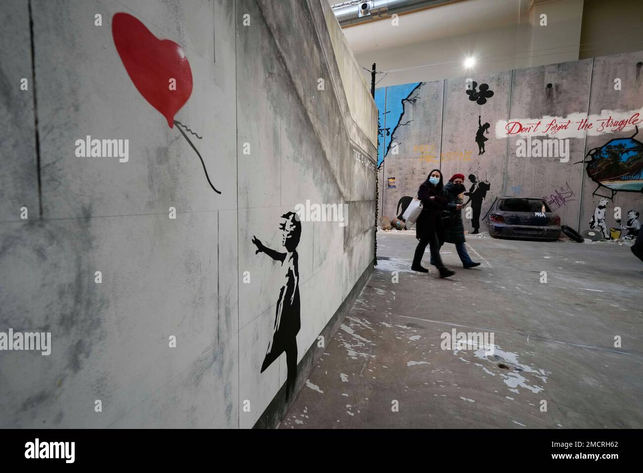 Oh medeklinker teugels Visitors walk past "Girl with balloon", a reproduction of a mural by  British artist Banksy, during the unveiling of the "The World of Banksy,  The Immersive Experience" exhibition, in Milan, Italy, Thursday,
