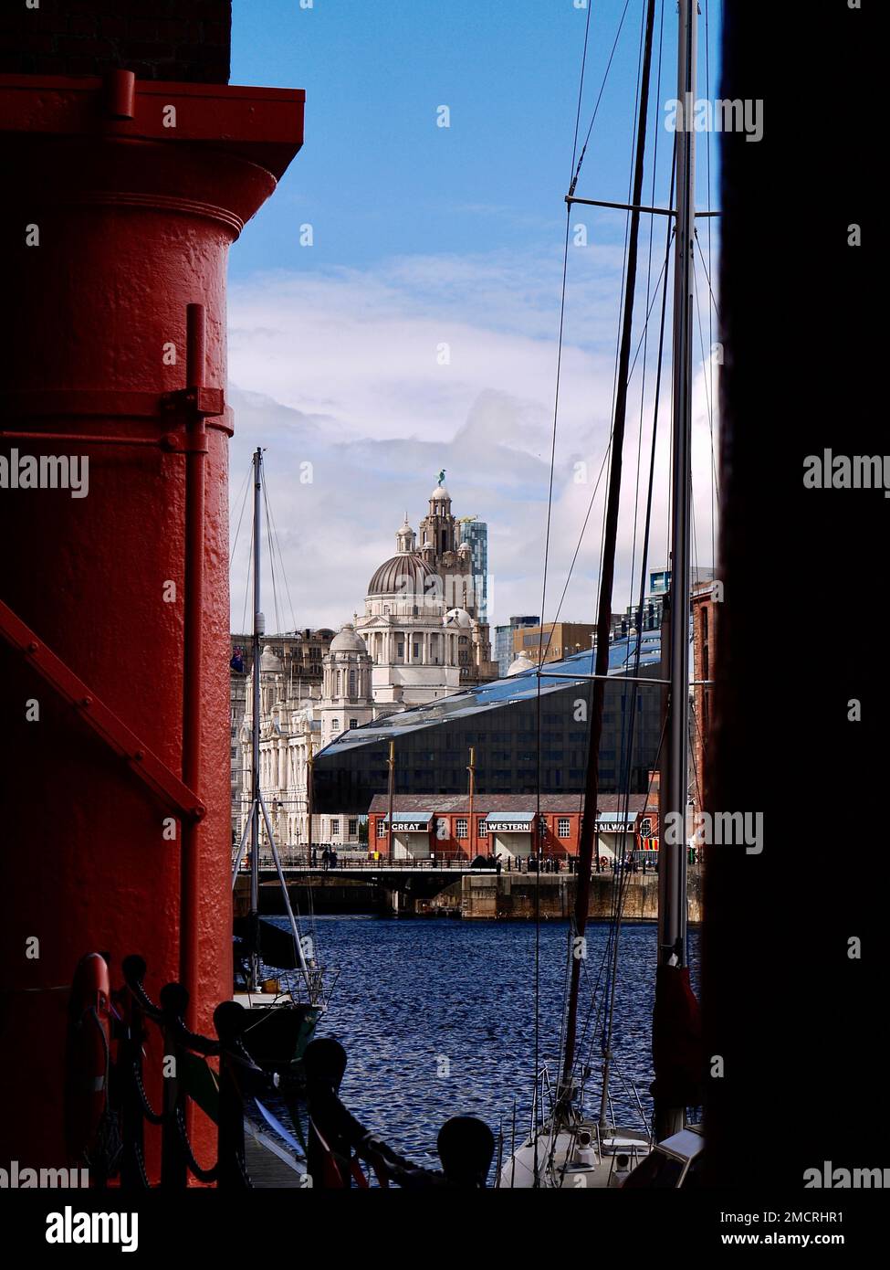 The Liver Building as seen through the imposing red painted columns of the refurbished Royal Albert Dock, Liverpool Stock Photo