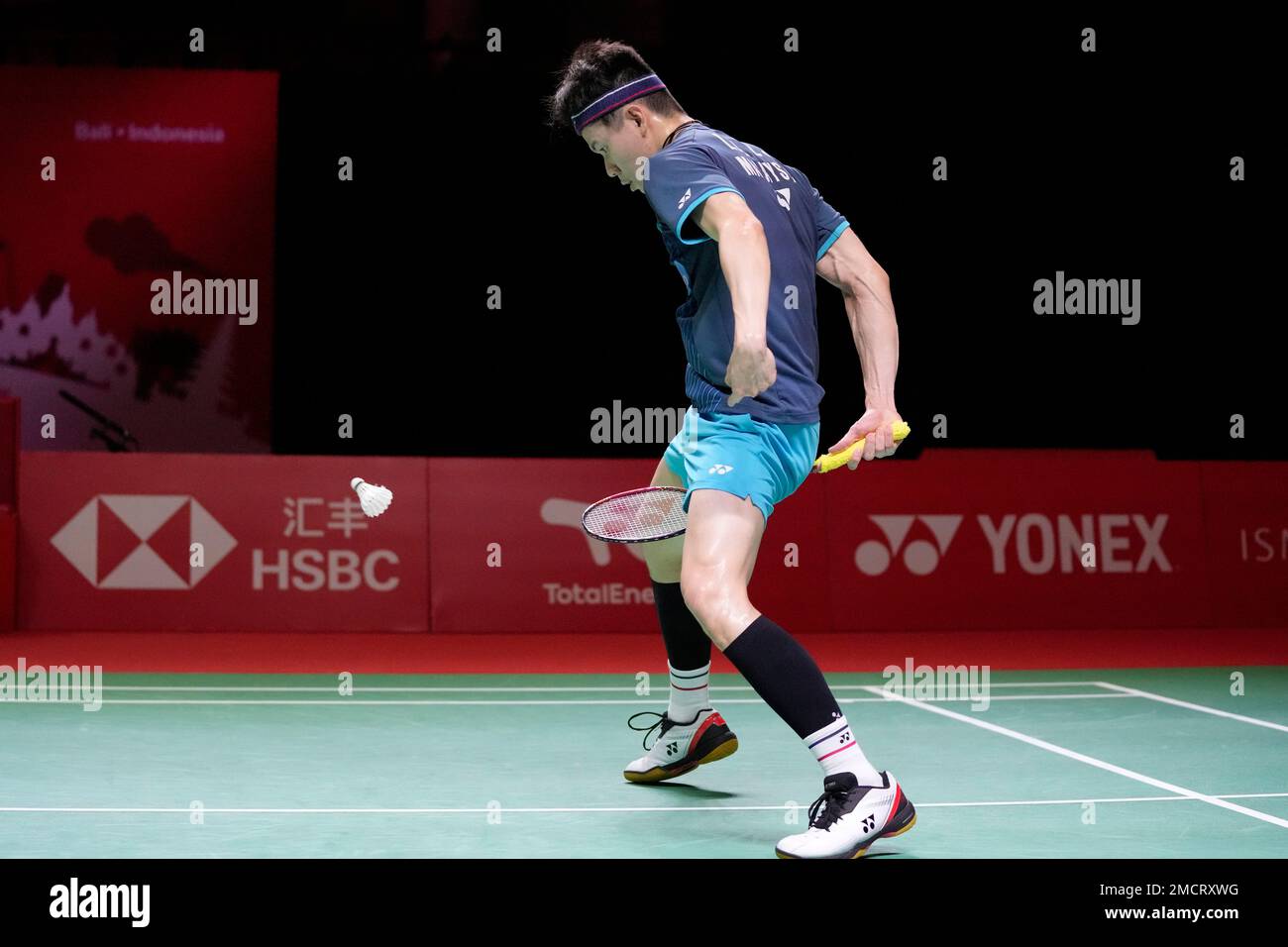 Malaysias Lee Zii Jia returns the shuttlecock fro between his legs as he competes against Thailands Kunlavut Vitidsarn during their mens singles Group B badminton match at the BWF World Tour Finals