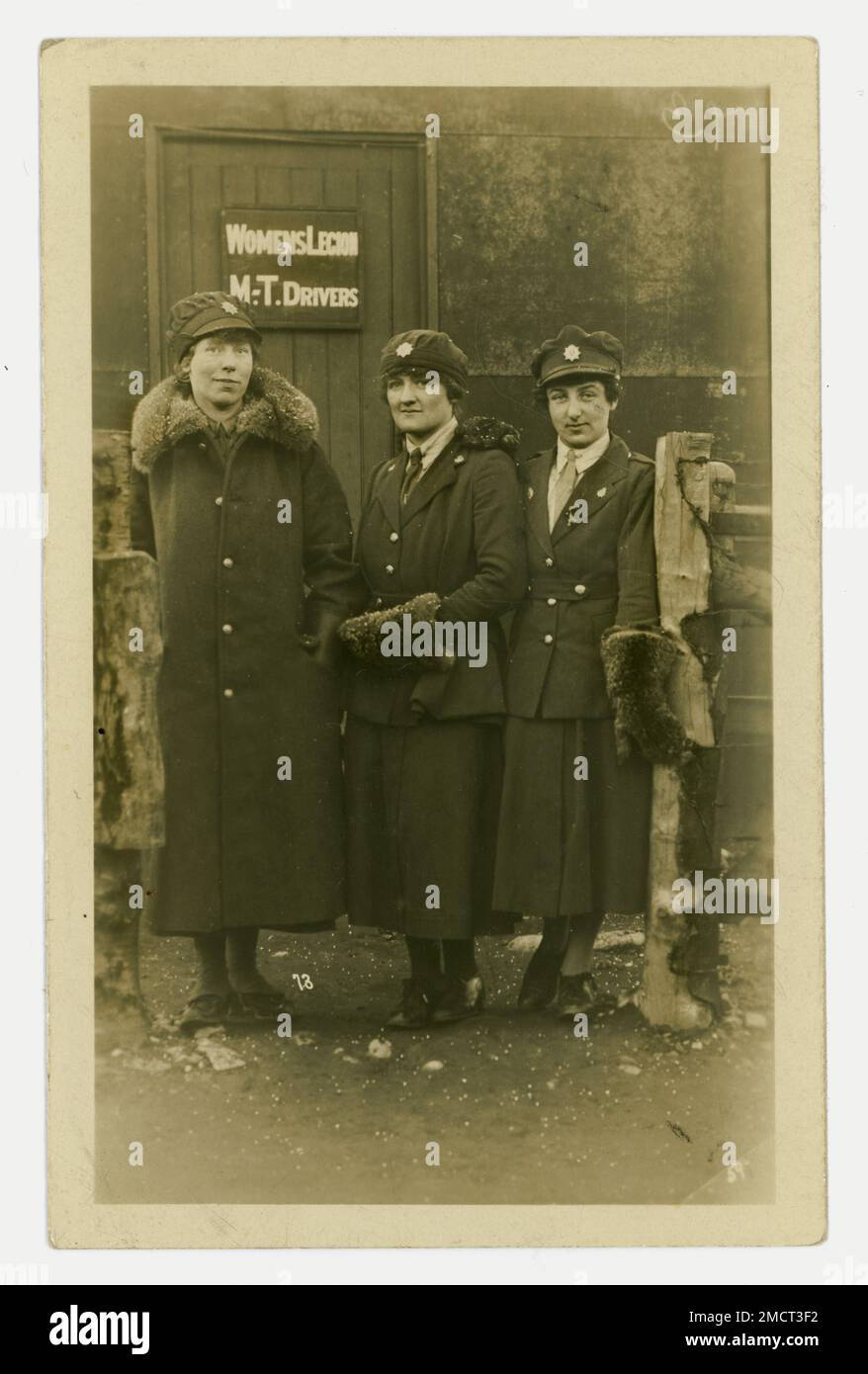 Original WW1 era postcard of a group of determined looking women standing next to a sign that says ' Women's Legion M.T. drivers. '  M.T. is an abbreviation of Mechanical / Motor Transport. The women are wearing uniform of khaki coat, skirt, cap and fur coat and gloves. On the women's cap and lapel badges are Army Service Corps (ASC) badges. Possibly drivers working with the Royal Flying Corps as they wore their ASC badge on their hat and shoulder. These Women's Legion motor drivers worked directly for the ASC on the home front.  Circa 1917 - 1918, U.K. Stock Photo