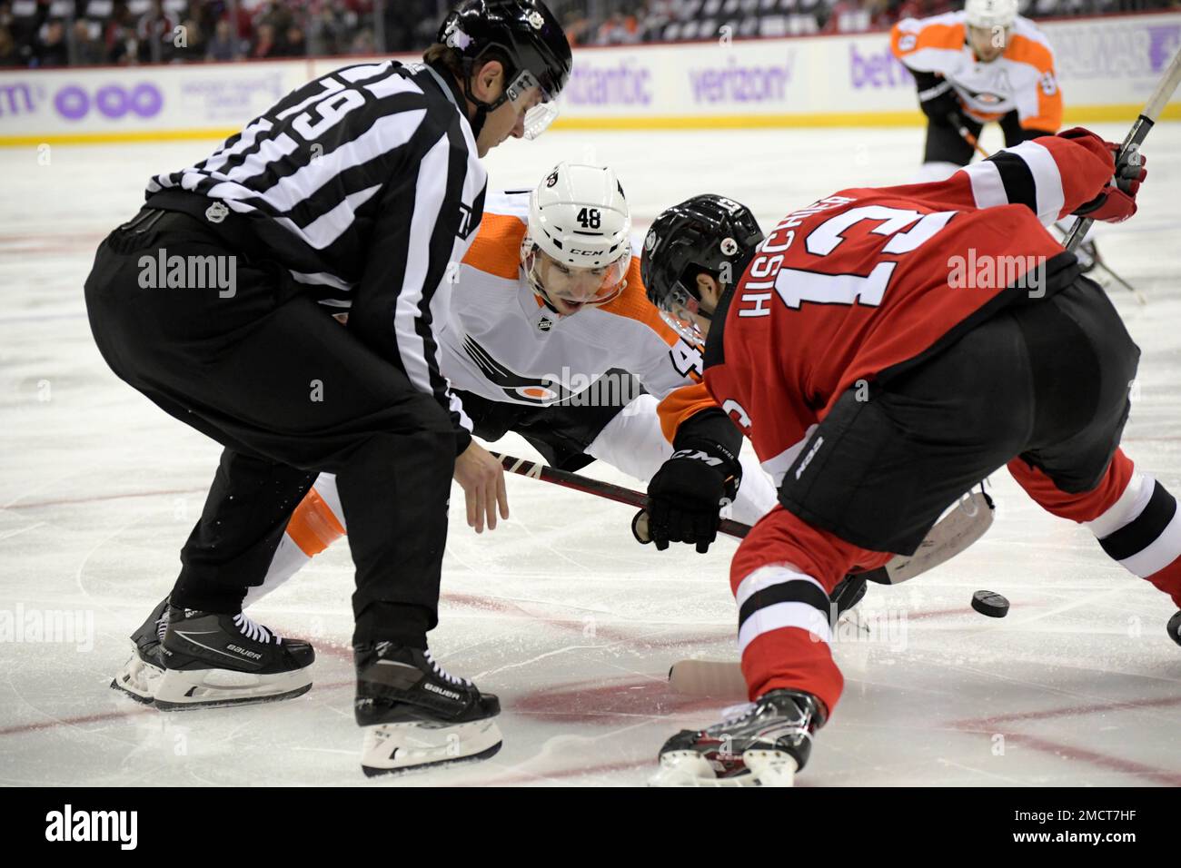 Linesman Kiel Murchison drops the puck for a faceoff between