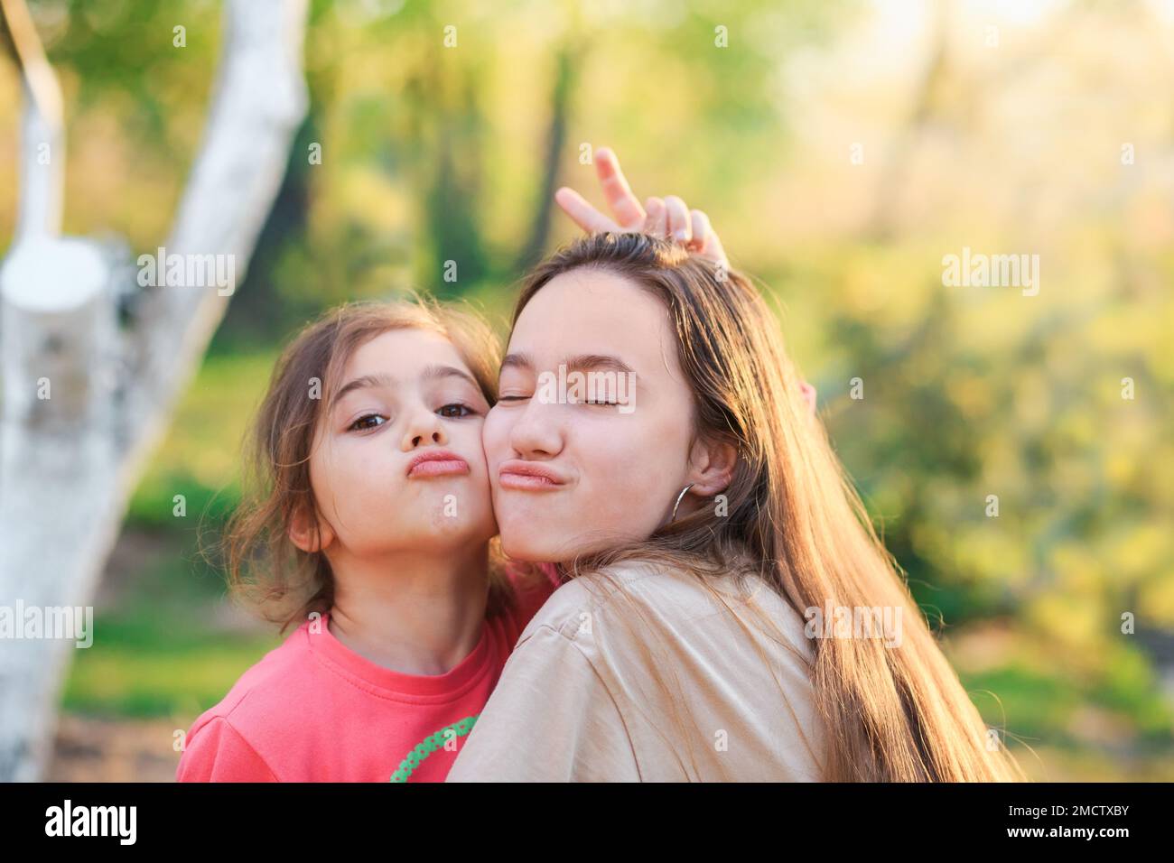 Two Cute little girls hugging and laughing at the countryside. Happy kids spending time  outdoors Stock Photo
