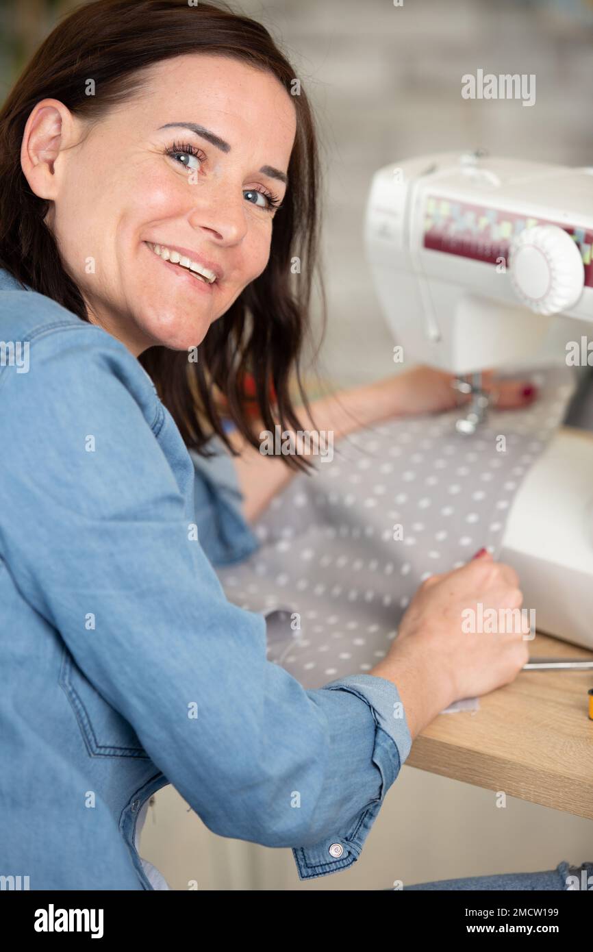 Premium Photo  Young dressmaker woman sews clothes on