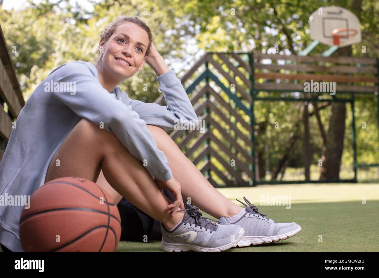 Woman in Pink Sweater Sitting on a Basketball · Free Stock Photo