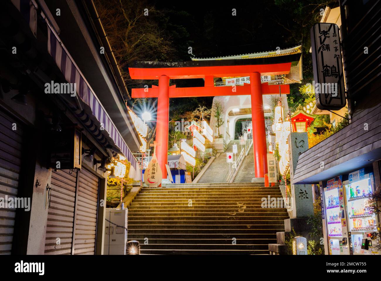 The vivid, vermilion lacquered torii is the gateway to the large Enoshima Shrine complex that consists of three main shrines located at the top of a w Stock Photo