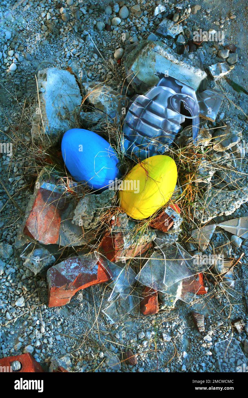 Ukraine Conflict, Deadly Easter 2022 in the Ukreine Blue and Yellow Egg and Egg Hand Grenade Lie in a Nest of Rubble and Shards Stock Photo