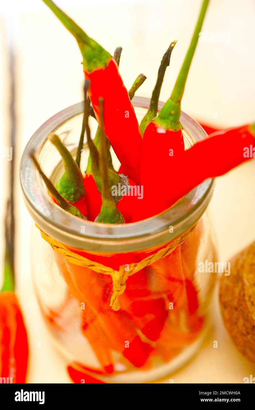 Red chili peppers on a glass jar over white wood rustic table Stock ...