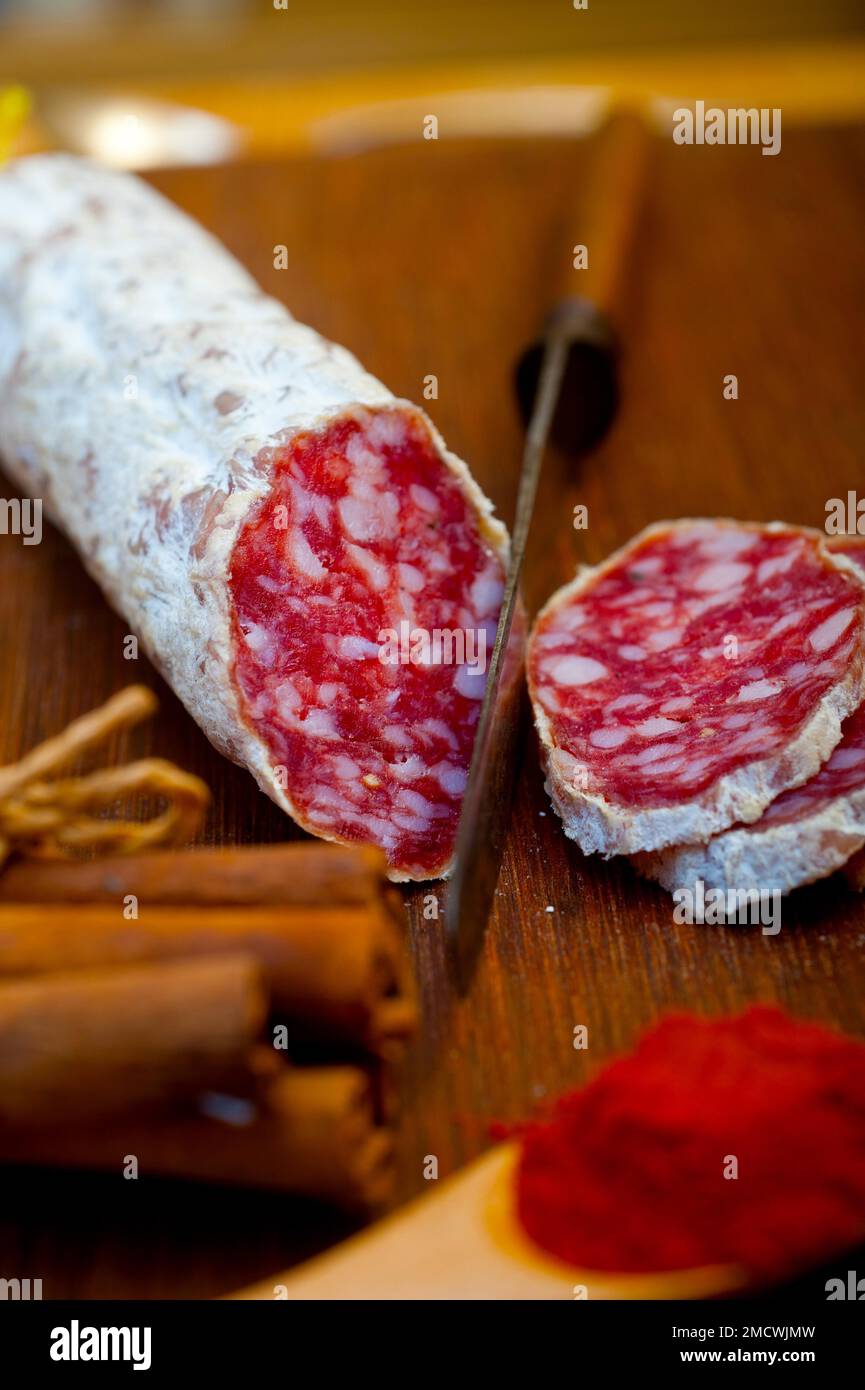 Traditional Italian salame cured sausage sliced on a wood board Stock Photo