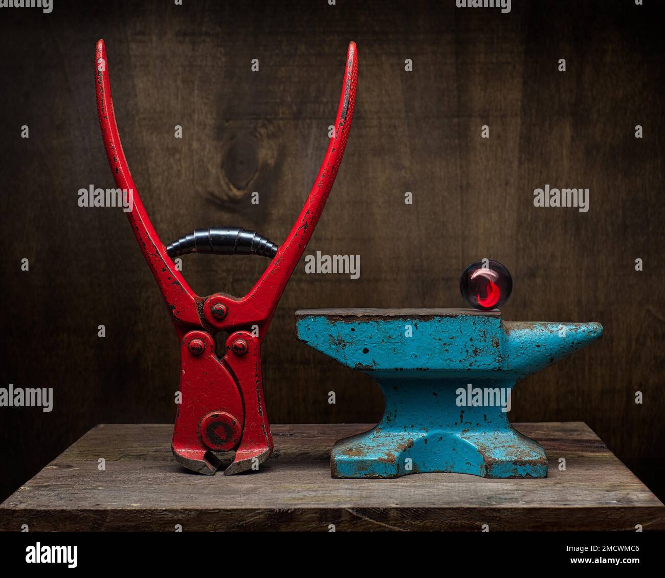 Theme Mysticism, superstition, astrology, still life with pincers and glass ball on old anvil, studio shot, symbol photo Stock Photo