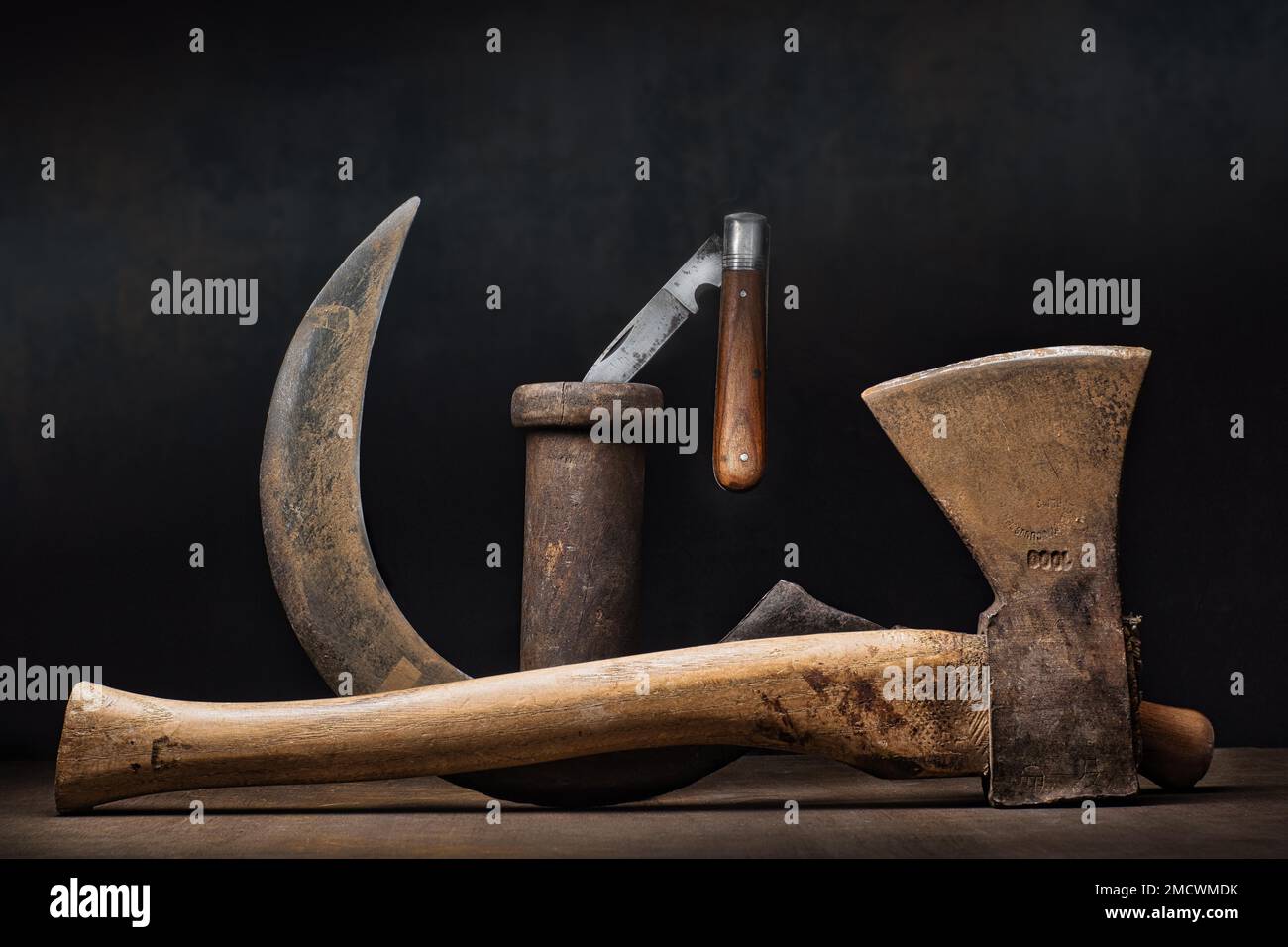 https://c8.alamy.com/comp/2MCWMDK/topic-craft-work-tool-diy-still-life-with-axe-sickle-and-pocket-knife-on-wooden-spool-studio-shot-symbol-photo-2MCWMDK.jpg