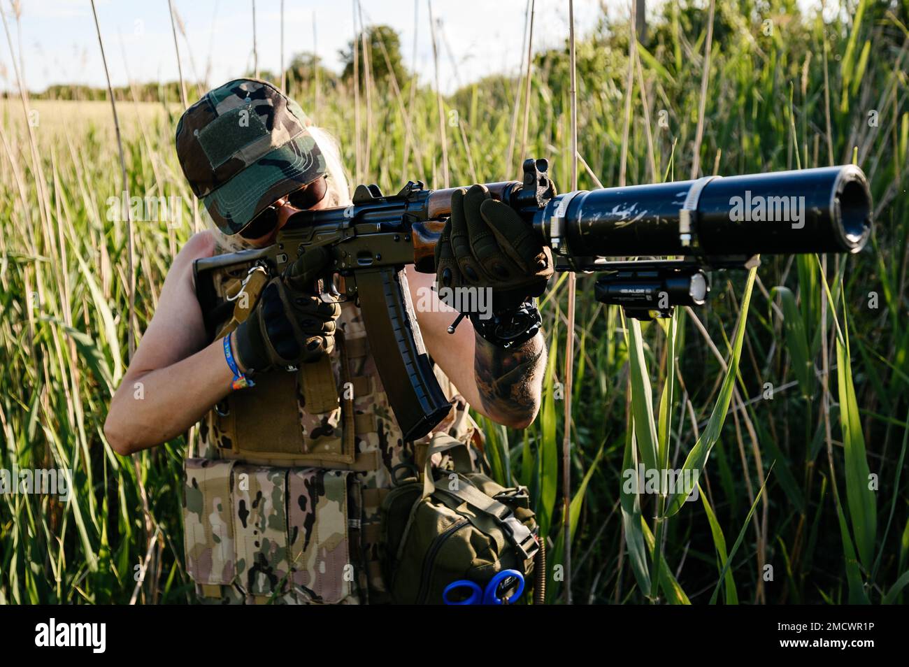 A combat medic is holding an automatic rifle aimed at the enemy, the Ukrainian army and its soldiers. Stock Photo