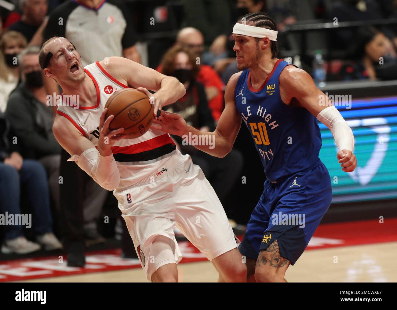 Portland Trail Blazers center Cody Zeller, left, looks to pass the ball