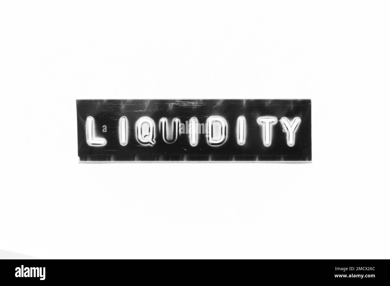 Embossed letter with word liquidity in black banner on white paper