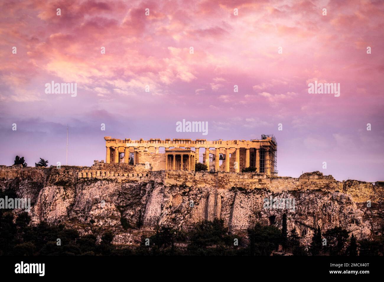 The Acropolis rises above Athens, Greece and is surrounded by a sunset glow. Stock Photo
