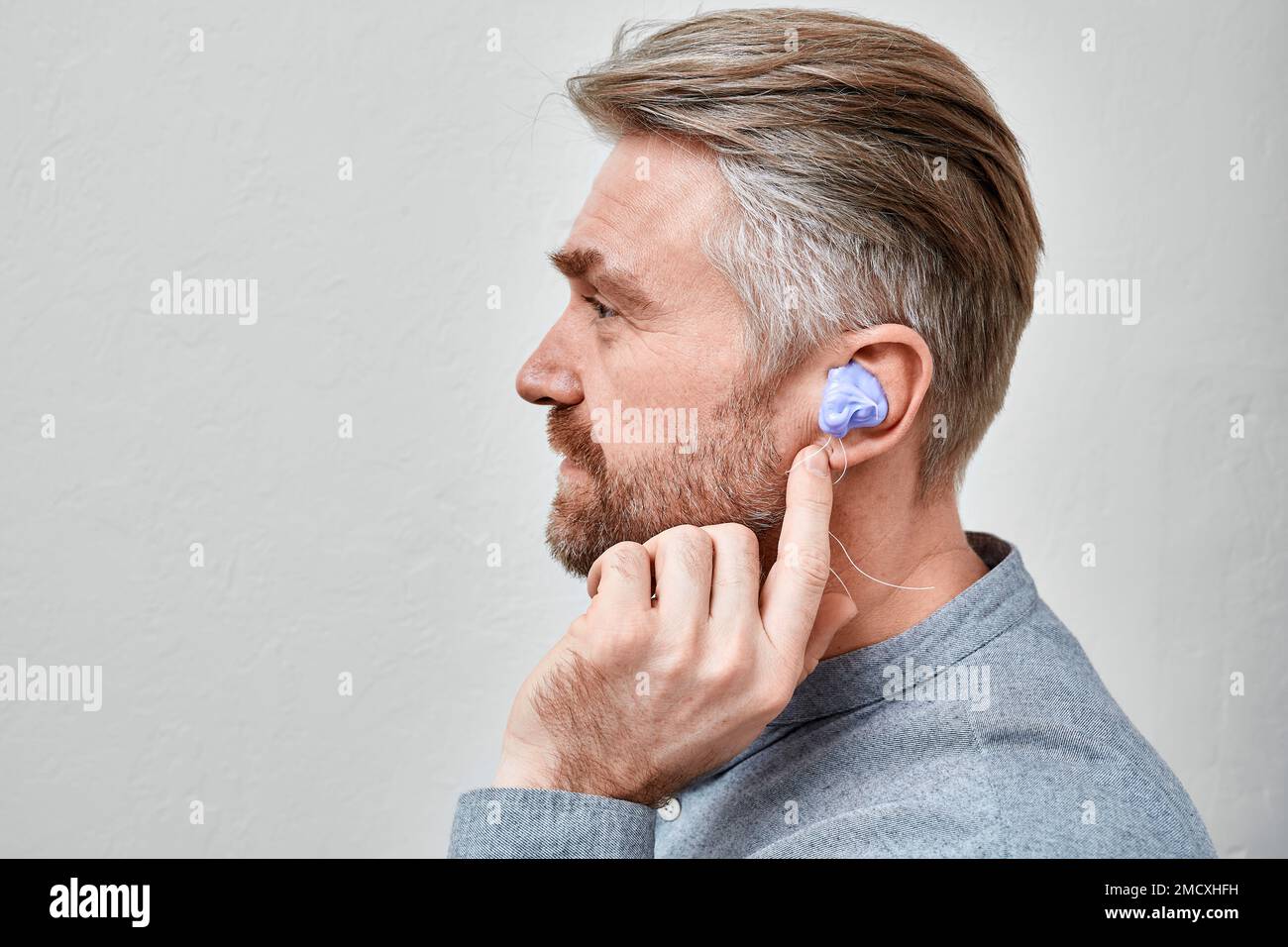 Making custom inear molds. Man with silicon material in ear while