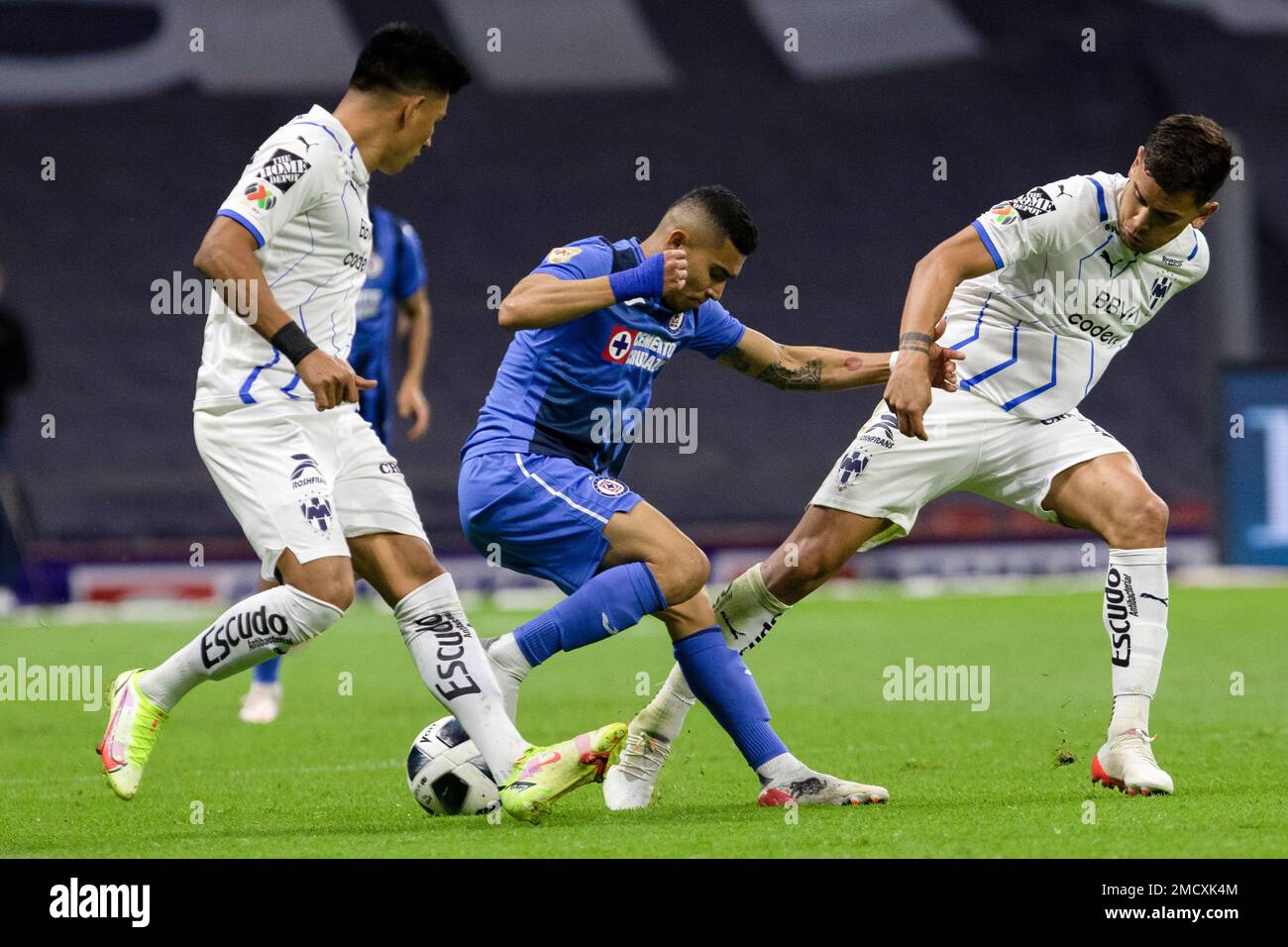 Cruz Azul's Orbelin Pineda, center, dribbles the ball against Monterrey