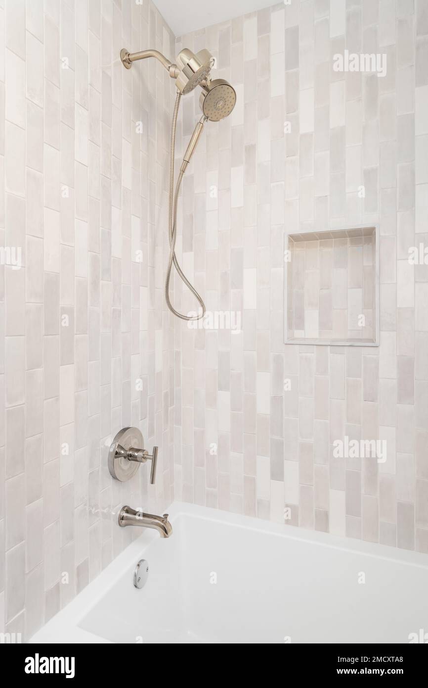 An empty shower with vertical brown subway tiles and small, a built-in ...