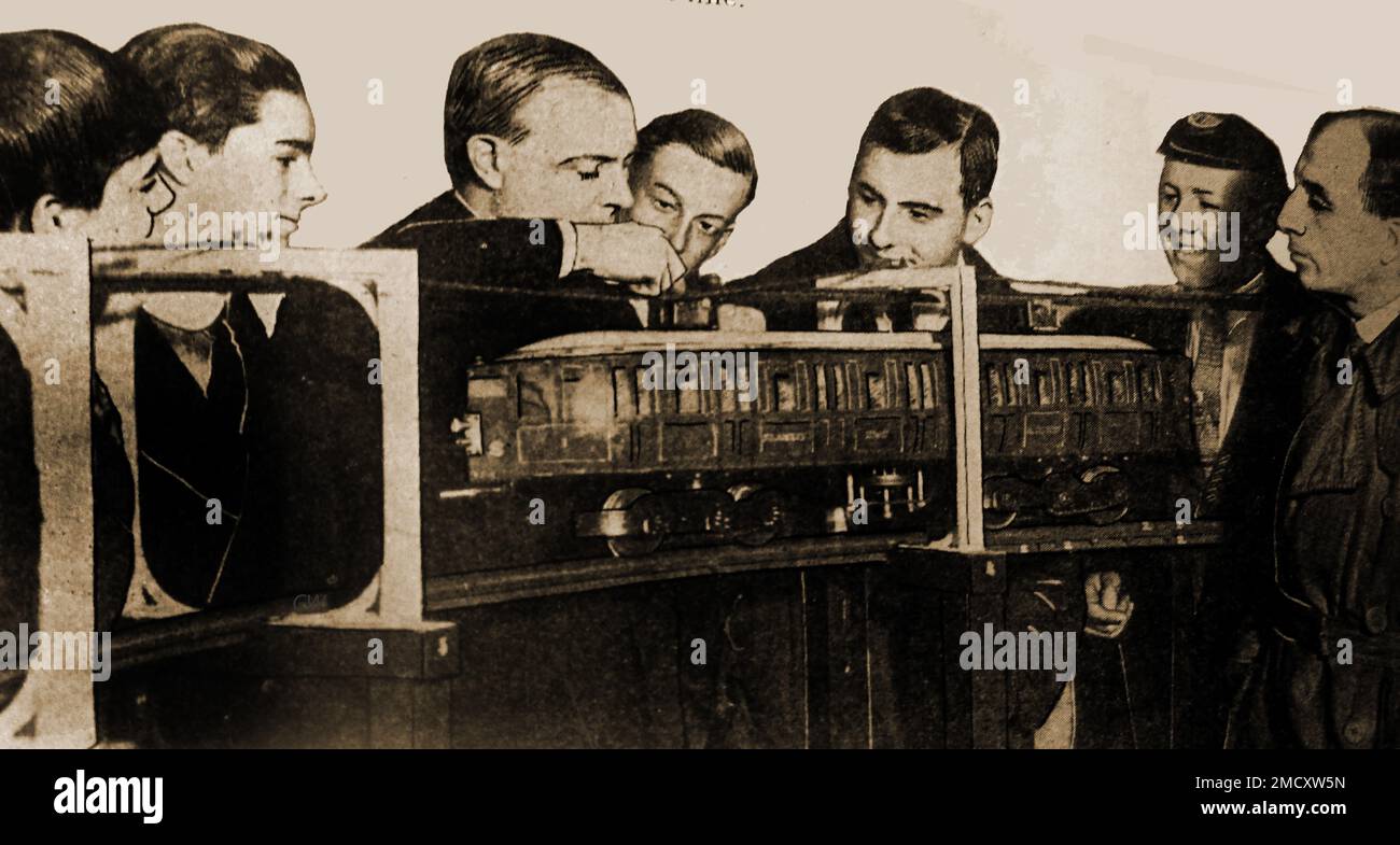 1930 image of E W Kearney explaining the workings of his monorail railway system..  Australian born Elfric Wells Chalmers Kearney (1881 – 1966 ) patented an innovative underground monorail railway system, which he called the Kearney High-Speed Tube, Though receiving popular acclaim in Britain, his invention never left the drawing board (apart from the model in the picture) Stock Photo