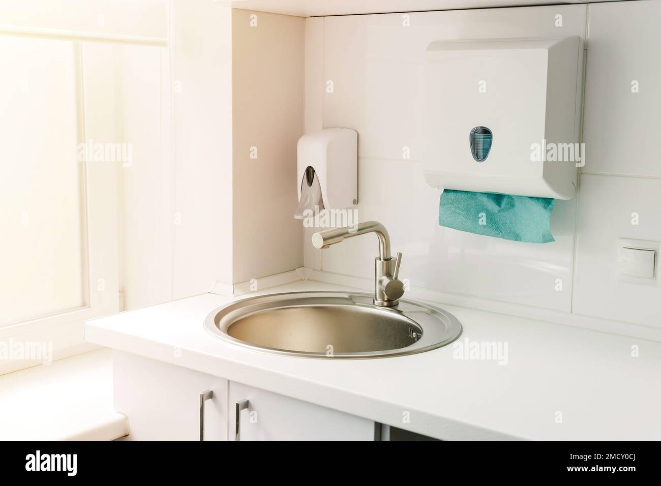 Modern hospital ward, hand washing sink, liquid soap disinfector automatic dispenser, paper towels. Stock Photo
