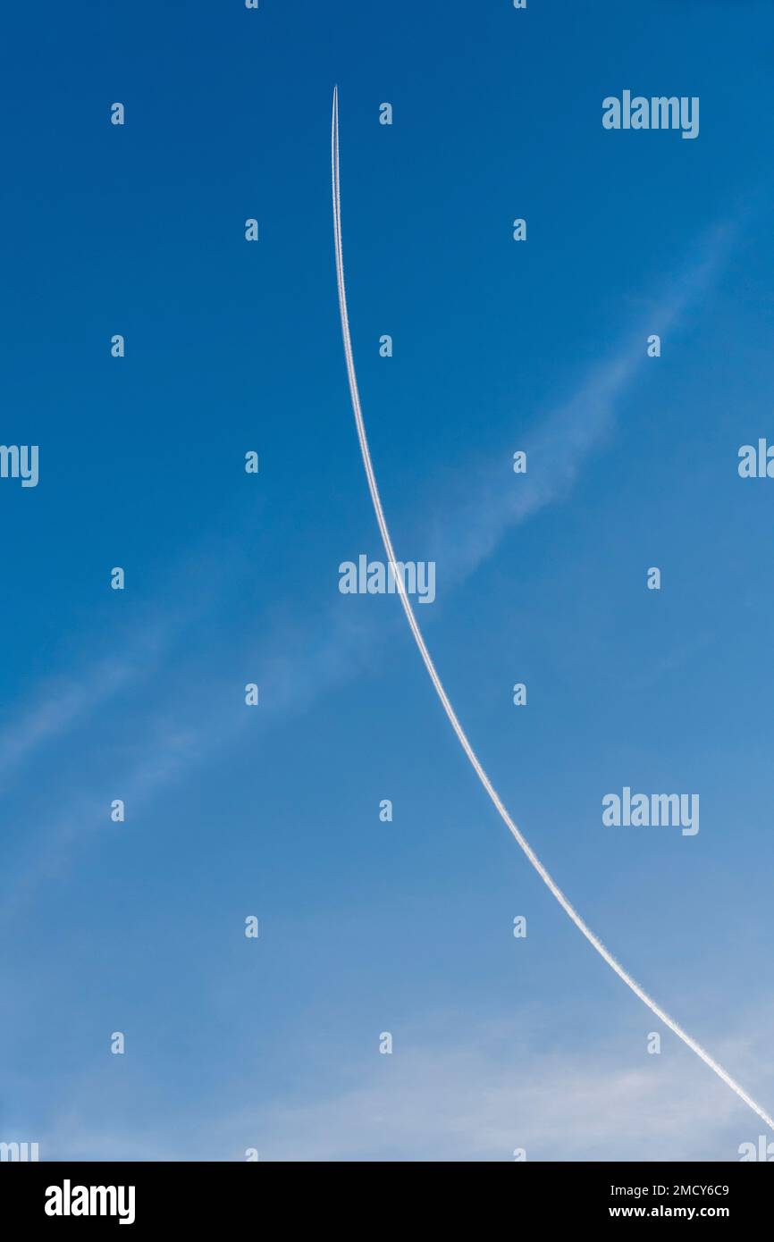 Aircraft with condensation trails in the sky Stock Photo