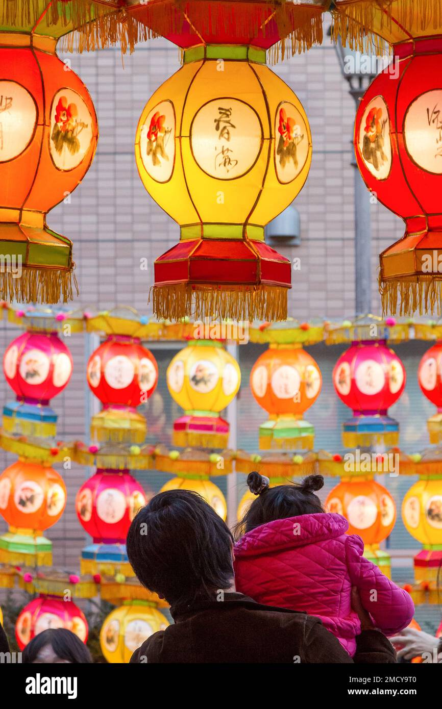Yokohama, Japan. 22nd Jan, 2023. A man lifts a child on his shoulders to look at colourful lanterns as part of the Chinese Spring Festival Yokohama China Town, Kanagawa. Traditional Chinese cultural events to mark the lunar new year will happen in Yokohama's China Town from January 22nd to February 5th, 2023. Credit: SOPA Images Limited/Alamy Live News Stock Photo