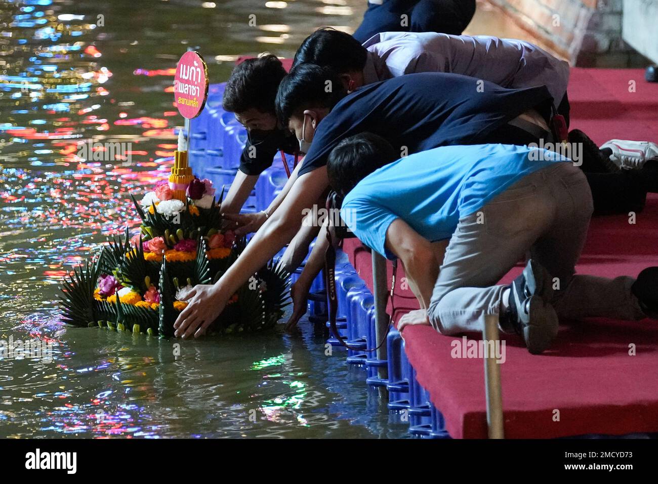 Thais place a krathong, a small boat made of banana tree and decorated