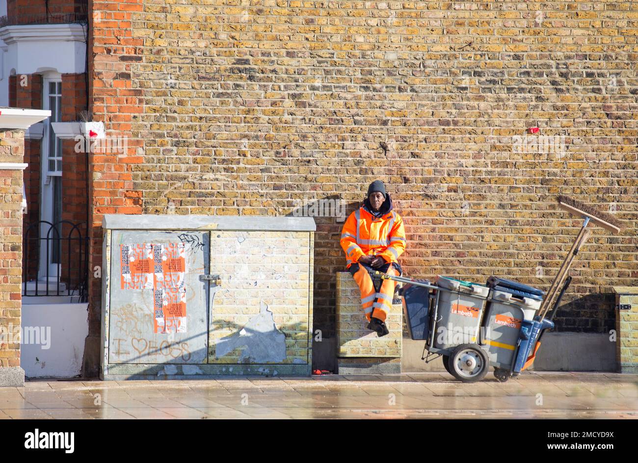 Lambeth Council street cleaner with broom relaxing in the sun Stock Photo