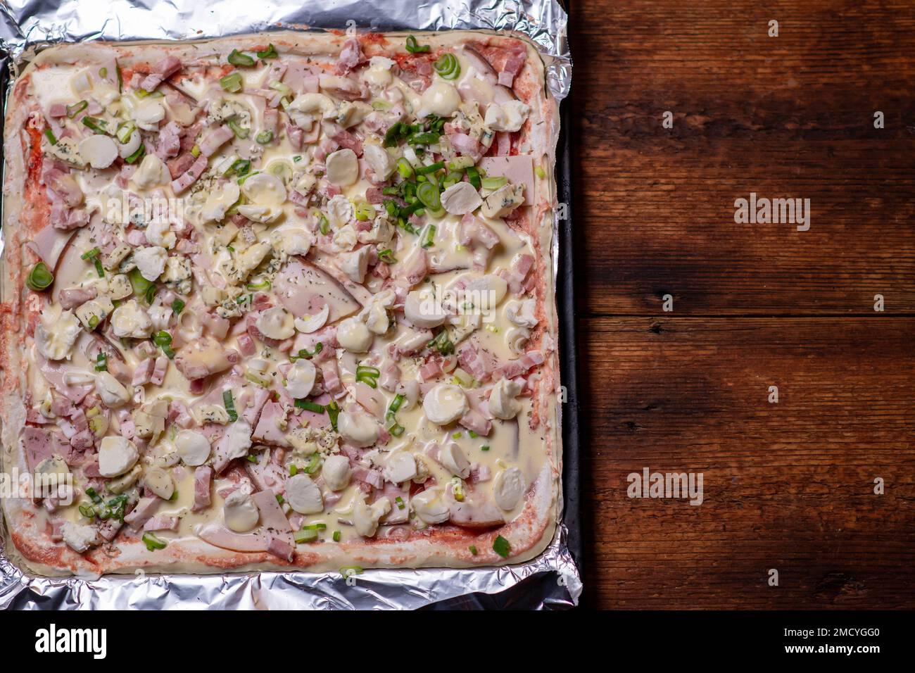 Cooking homemade pizza on a baking sheet. Pizza with mozzarella cheese