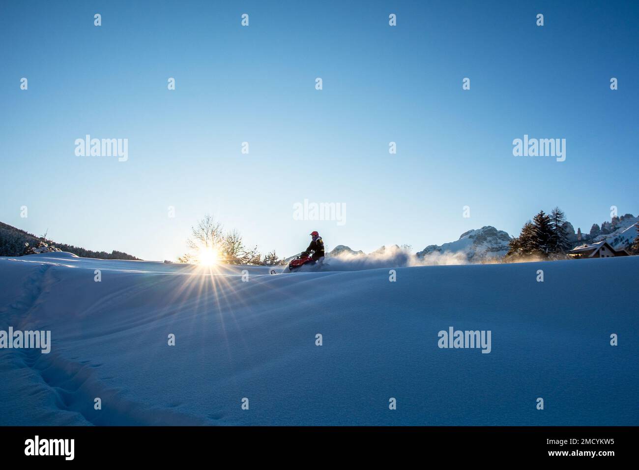 Man on snowmobile in snowy landscape Trentino Alto Adige, Northern Italy Stock Photo