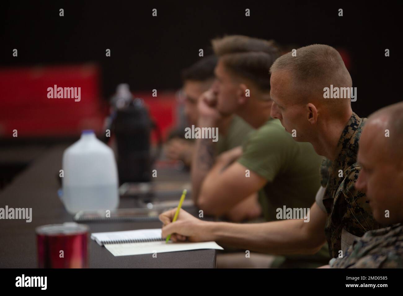 U.S. Marines with Fleet Marine Force, Atlantic, Marine Forces Command, Marine Forces Northern Command, their respective Headquarters and Service Battalion, Marine Corps Security Force Regiment, Marine Detachment, Naval School of Music, Center for Naval Aviation Technical Training Unit Oceana, and Marine Corps Intelligence Schools take notes during a High Intensity Tactical Training (HITT) course in the Hopkins Hall Gymnasium at Camp Elmore, Virginia, July 11, 2022. HITT is a comprehensive strength and conditioning program that focuses on maintaining and improving physical resiliency and combat Stock Photo