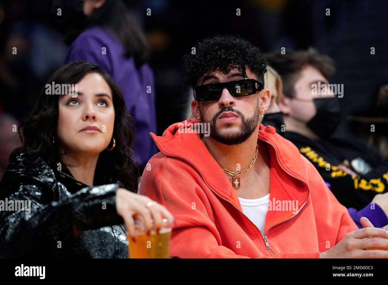 Entertainer Bad Bunny, right, attends during the first half of an