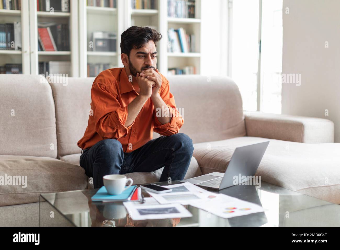 Pensive arab man working from home, looking for solution Stock Photo
